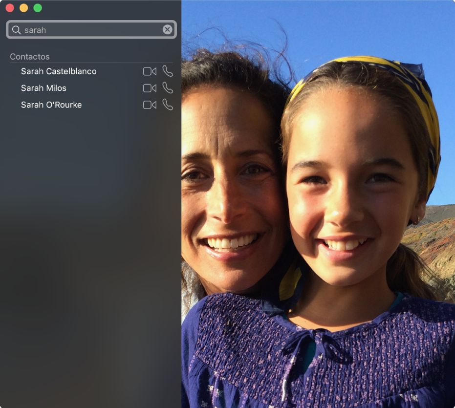 La ventana de FaceTime antes de realizar una llamada. En la esquina superior izquierda hay un campo de búsqueda que dice “Sara” y debajo se encuentra una lista de los resultados, incluyendo contactos con el nombre Sara con botones que permiten iniciar una llamada de audio o video. A la derecha se ve lo que tu cámara está mostrando: dos personas listas para una llamada.