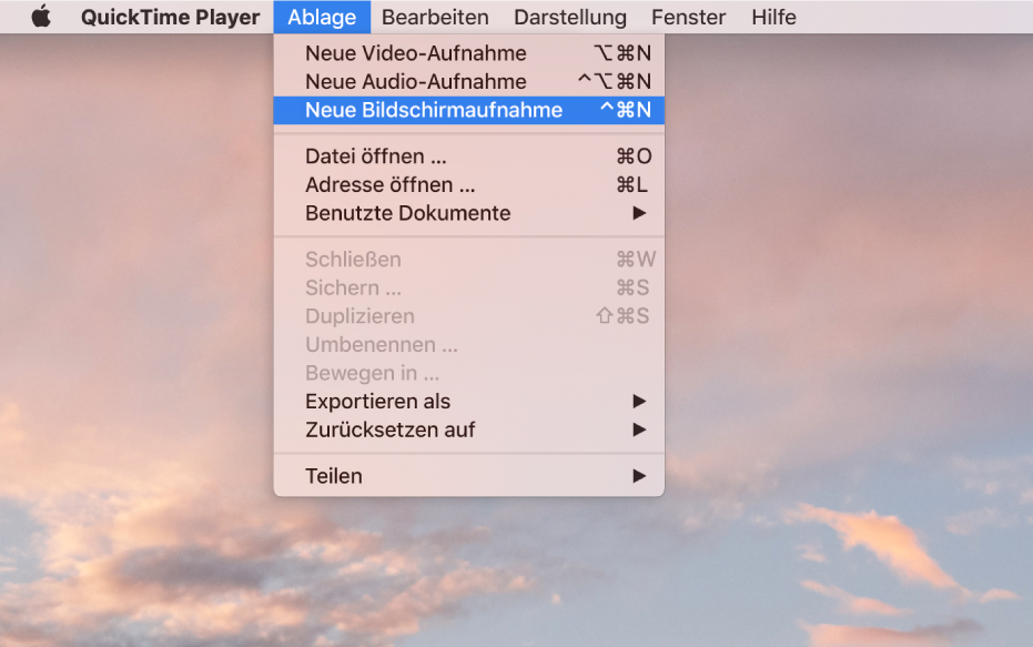 In der App „QuickTime Player“ ist das Menü „Ablage“ geöffnet und der Befehl „Neue Bildschirmaufnahme“ ist ausgewählt, um die Aufnahme des Bildschirms zu starten.