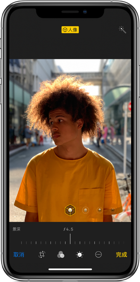 “人像”模式照片的“编辑”屏幕。照片位于屏幕中央,下方是用于调整“景深控制”的滑块。滑块下方从左到右依次是“取消”、“裁剪”“滤镜”、“计时器”、“更多”和“完成”按钮。
