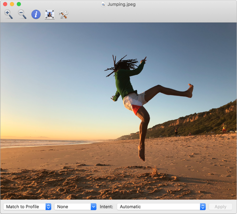 The ColorSync Utility window showing an image of a man jumping in the air on a beach.