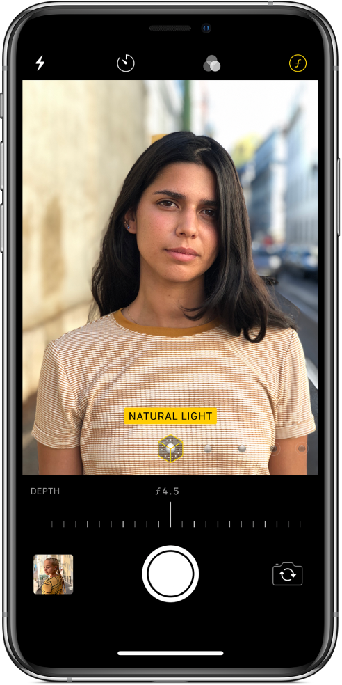 The Camera screen in Portrait mode. The Depth Adjustment button in the top right corner of the screen is selected. In the camera viewer, a box shows that the Portrait Lighting option is set to Natural Light, and there’s a slider to change the lighting option. Below the camera viewer, there is a slider to adjust the Depth Control.