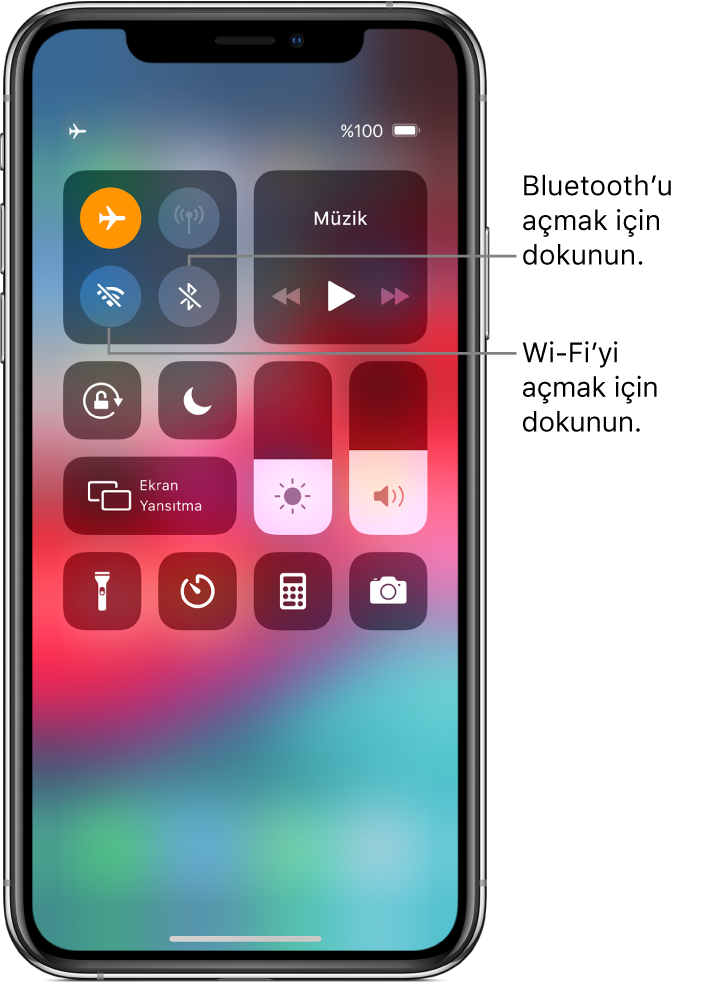 Uçak modunun açık olduğu ve sol üst taraftaki denetim grubunun sol üst düğmesine dokunmanın Wi-Fi’yi, aynı grupta sağ üstteki düğmeye dokunmanın Bluetooth’u açtığını açıklayan belirtme çizgileriyle Denetim Merkezi.