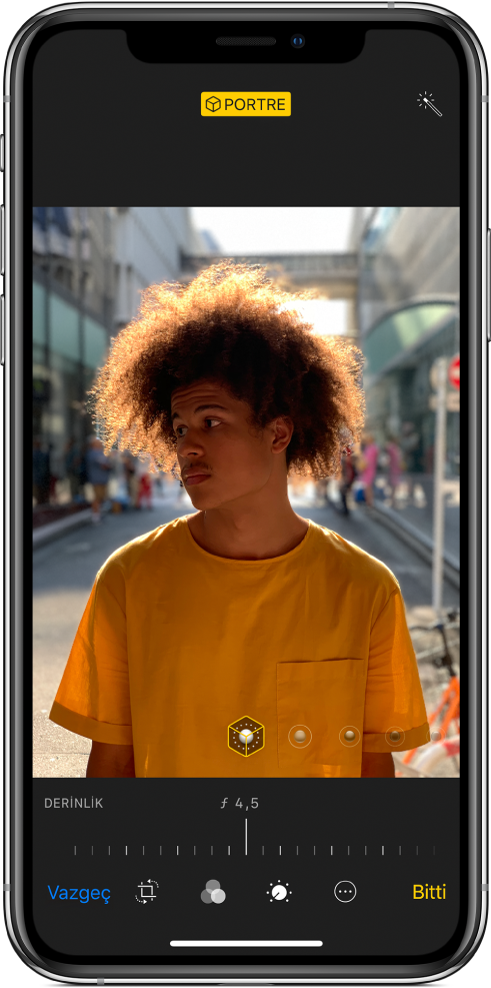 Portre modu fotoğrafının Düzenle ekranı. Ekranın ortasında fotoğraf var ve fotoğrafın altında Derinlik Denetimini ayarlamak için bir sürgü bulunuyor. Sürgünün altında soldan sağa doğru Vazgeç, Kes, Filtreler, Ayarlamalar, Daha Fazla ve Bitti düğmeleri bulunuyor.