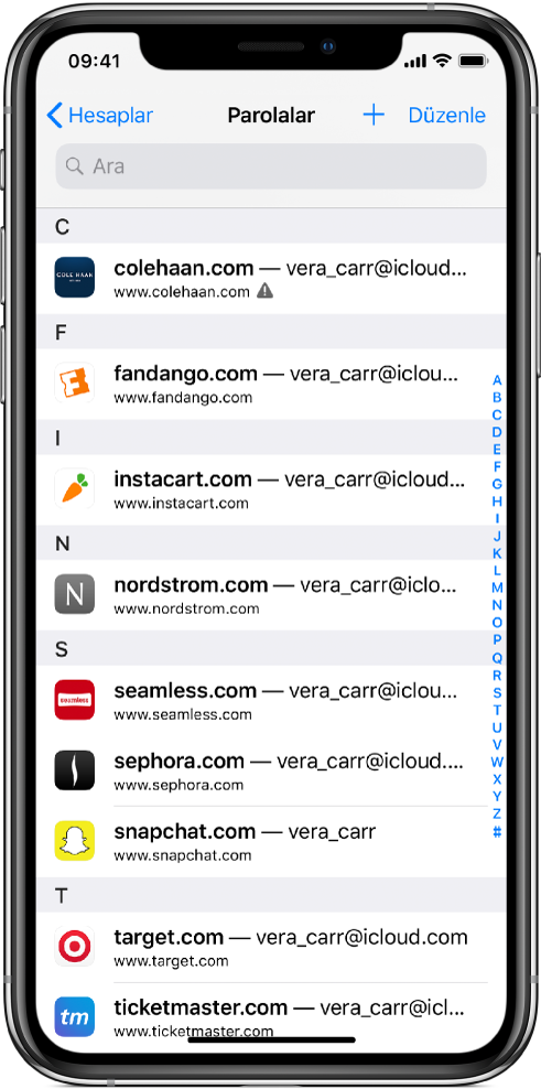 Web sitelerinin ve bu sitelerde kullanılan hesap adlarının alfabetik listesini gösteren bir parola ekranı. Listelenen ilk web sitesinin URL’sinin yanında parolanın daha önce kullanıldığı uyarısı var.