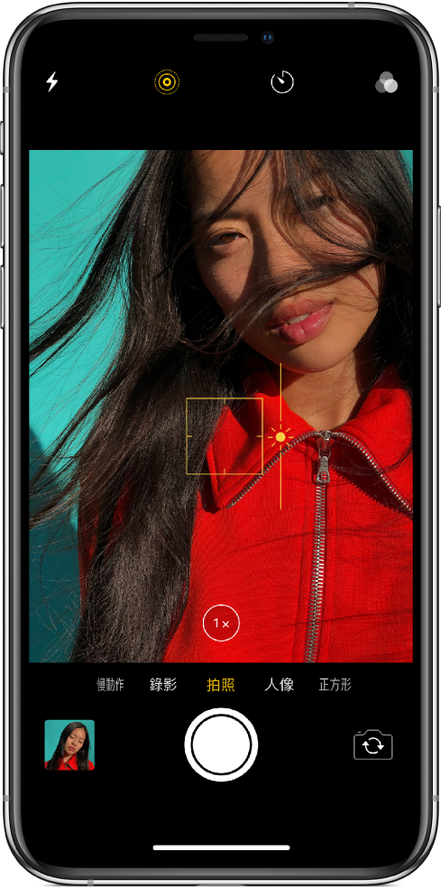 使用「拍照」模式的「相機」畫面。在觀景窗中，黃色方框會顯示對焦區域，您可以上下拖移滑桿來調整曝光值。可使用「1 倍縮放」按鈕來放大。