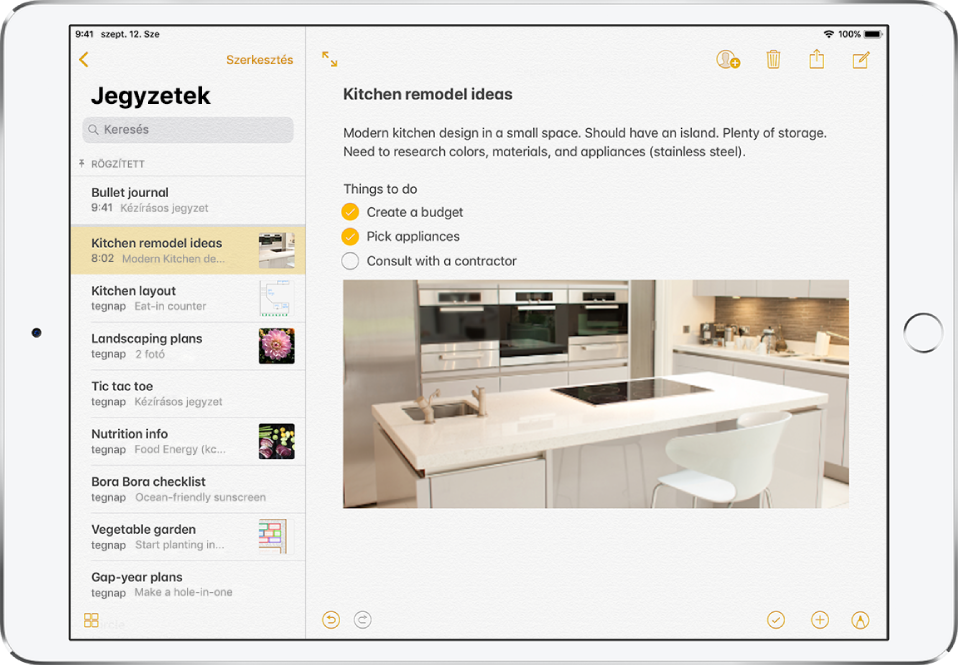 Az iPad vízszintes pozícióban a megnyitott Jegyzetek alkalmazással. A képernyő bal oldalán a jegyzetlista látható, jobb oldalon pedig a kiválasztott jegyzet van megnyitva. A jegyzetlista bal felső sarkában egy visszafelé mutató nyíl található, amelyre koppintva megtekintheti a mappákat és fiókokat. A jegyzetlista bal alsó sarkában található gombra koppintva megjelenítheti az összes mellékletet. A jegyzet jobb felső sarkában lévő gombok lehetővé teszik, hogy együttműködjön másokkal a jegyzeten, törölje a jegyzetet, megossza a jegyzetet másokkal, vagy új jegyzetet hozzon létre. A jegyzet jobb alsó sarkában lévő gombok ellenőrzőlista létrehozására, fotó, videó vagy szkennelt dokumentum hozzáadására, illetve korrektúrázásra használhatók.