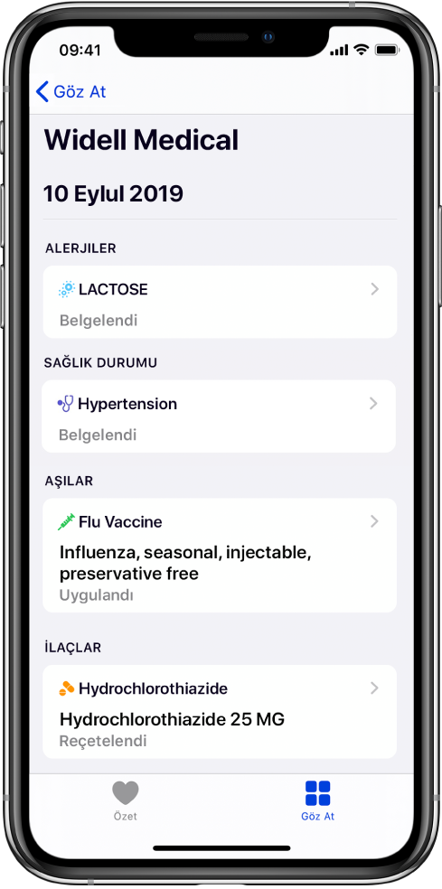 Sağlık uygulamasında ekranın üst kısmına yakın bir yerde “Widell Medical” başlığı görünür. Başlığın altında çeşitli sağlık kaydı türleri hakkında bilgiler görünür. Alerji üst kategorisi bir kayıt, Laktoz (Belgelendi) içeriyor. Sağdaki bir denetim oku kayıt için daha fazla bilginin olduğunu gösterir. Ekran Hastalıklar, Alerjiler ve İlaçlar kategorisi için ek sağlık kayıtlarını içerir.