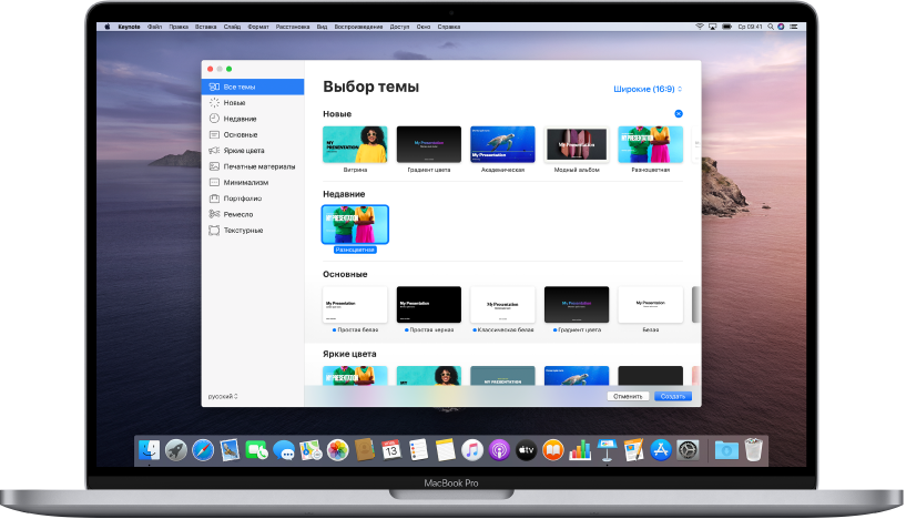 MacBook Pro с открытым окном выбора темы Keynote. Слева выбрана категория «Все темы», справа отображаются готовые темы, упорядоченные в ряды по категориям. Всплывающее меню «Язык и регион» находится в левом нижнем углу, а всплывающее меню выбора формата тем — «Стандартные» и «Широкие» — в правом нижнем углу.