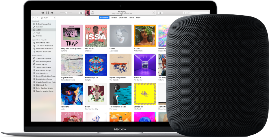 Ein MacBook mit iTunes auf dem Bildschirm und einem HomePod in der Nähe