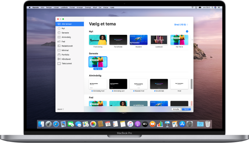 En MacBook Pro med temavælgeren i Keynote åben på skærmen. Kategorien Alle temaer er valgt til venstre, og til højre vises færdige temaer i rækker efter kategori. Lokalmenuen Sprog & område ses i hjørnet nederst til venstre og lokalmenuen Standard og Bred ses i hjørnet øverst til højre.