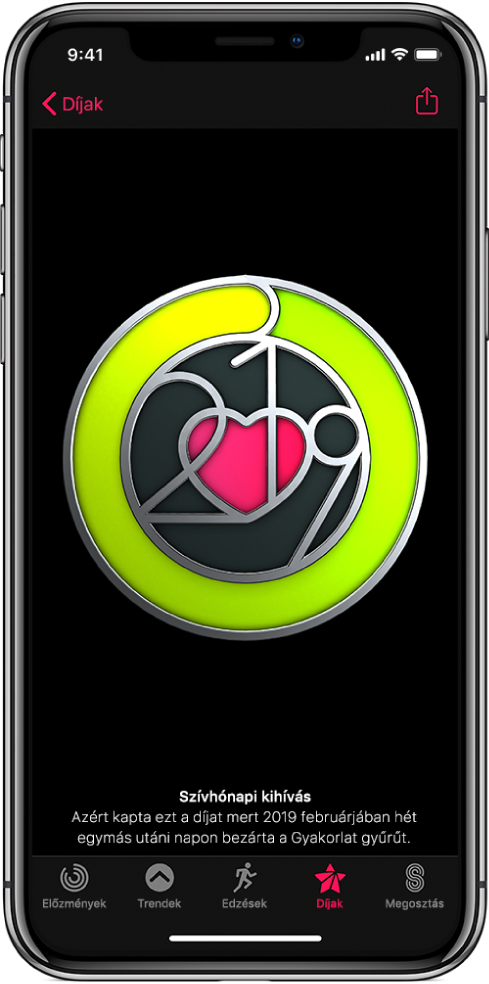 A Tevékenység alkalmazás Díjak képernyője az iPhone-on; a képernyő közepén díj látható. Húzással forgathatja a díjat. A Megosztás gomb a jobb felső sarokban látható.