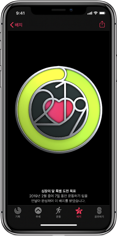 화면 중앙에 목표 달성 배지가 표시되어 있는 iPhone의 활동 앱 화면의 배지 탭. 배지를 드래그하여 회전할 수 있음. 공유 버튼이 오른쪽 상단에 있음.