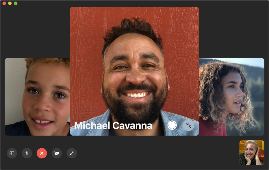 The FaceTime window showing a group call. The person who initiated the call is shown in a tile in the bottom-right corner. A large tile in the middle of the window shows a participant, along with a Live Photo button in the middle of the tile that callers can click to capture the moment.