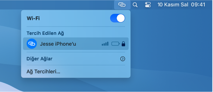 Bir iPhone’a bağlı Kişisel Erişim Noktası’nı gösteren Wi-Fi menüsünün bulunduğu Mac ekranı.
