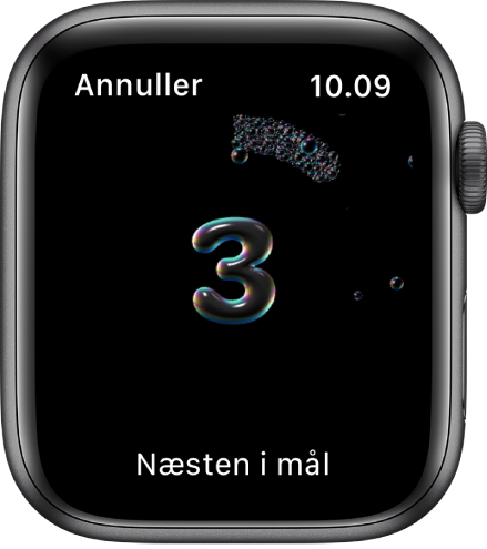 Håndvasktælleren, hvor der tælles ned fra 3. Ordene “Næsten i mål” er vist forneden på skærmen.
