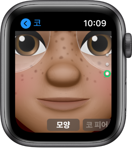코 편집 화면을 보여주는 Apple Watch의 미모티콘 앱. 코에 초점을 맞추어 얼굴을 클로즈업함. 아래에 모양이라는 단어가 나타남.