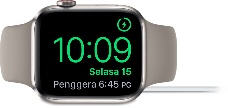 Apple Watch diletakkan di sisi dan bersambung ke pengecas, dengan skrin menunjukkan simbol mengecas di penjuru atas kanan, masa semasa di bawahnya dan penggera di sebelahnya.