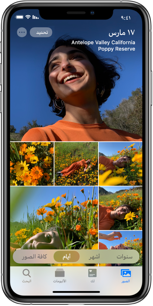 مكتبة الصور معروضة في عرض الأيام. مجموعة من الصور المصغرة تملأ الشاشة. في الزاوية العلوية اليمنى من الشاشة يوجد تاريخ وموقع التقاط الصور. في الزاوية العلوية اليسرى يوجد الزران تحديد والمزيد من الخيارات؛ اضغط على تحديد لمشاركة الصور والمزيد من الخيارات لتفاصيل الصورة. تحت الصور المصغرة توجد خيارات لعرض مكتبة الصور حسب السنوات والأشهر والأيام وكافة الصور. على طول الجزء السفلي توجد علامات التبويب الصور ولك والألبومات وبحث.