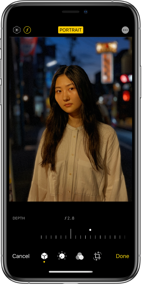 The Edit screen of a Portrait mode photo. At the top left of the screen is the Lighting Intensity button and the Depth Adjustment button. At the top center of the screen the Portrait button is on and at the top right is the Plug-ins button. The photo is in the center of the screen and below the photo is a slider to adjust the Depth Adjustment setting. Below the slider from left to right are the Cancel, Portrait, Adjust, Filters, Crop, and Done buttons.