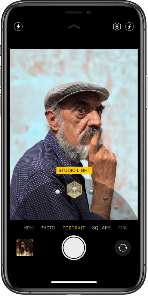 The Camera screen with Portrait mode selected. In the viewer, a box shows that the Portrait Lighting option is set to Studio Light, and there’s a slider to change the lighting option.