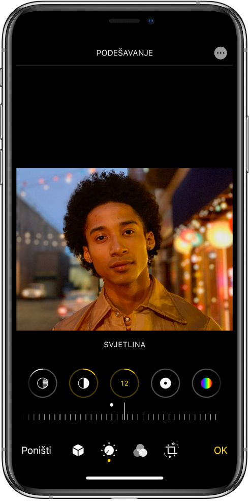 Zaslon Uredi s fotografijom po sredini. Ispod fotografije nalaze se tipke za uređivanje za Istaknuto, Sjene, Svjetlina, Crna točka i Zasićenje. Odabrana je Svjetlina. Ispod tipki uređivanja nalazi se kliznik koji prilagođava razine Svjetline. Ispod kliznika se s lijeva na desno nalaze tipke Poništi, Izreži, Portret, Uredi, Filtri, Izreži i OK. Tipka Više opcija nalazi se u gornjem desnom kutu.