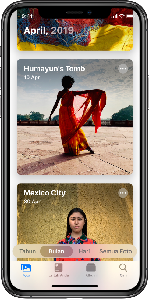 Skrin dalam app Foto. Tab Foto dan paparan Bulan dipilih Dua acara dari April 2019, Makam Humayun dan Bandar Mexico dipaparkan.