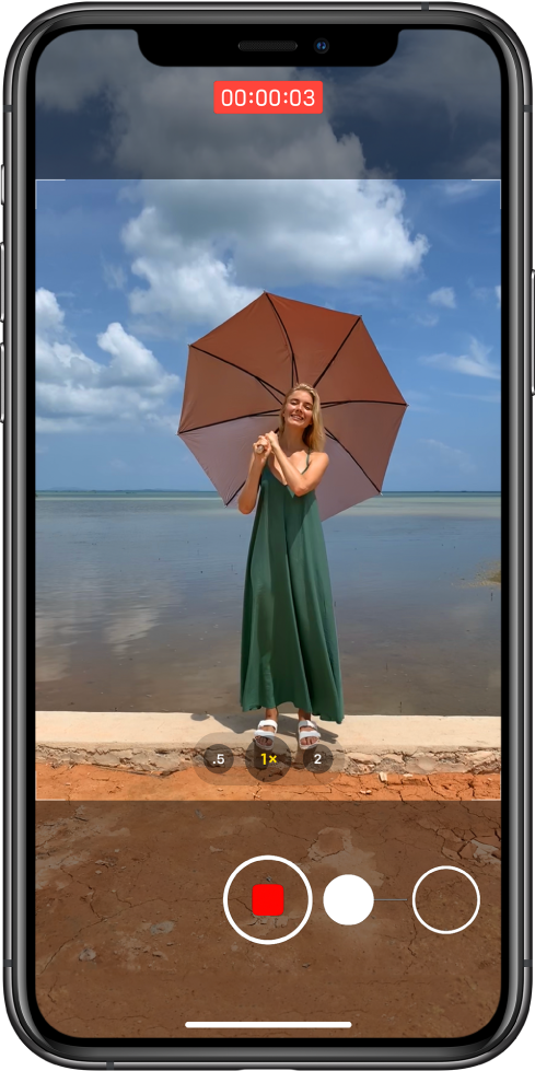 Zaslon aplikacije »Camera«, ki prikazuje premik za začetek snemanja videoposnetka QuickTake. Ob dnu zaslona se gumb »Shutter« premakne desno proti gumbu »Lock«, kar prikazuje gib za začetek snemanja videoposnetka QuickTake v načinu »Photo«. Na vrhu zaslona je prikazan časovnik snemanja.