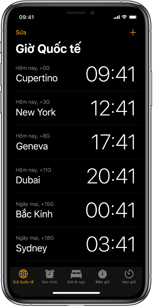 Tab Giờ quốc tế, đang hiển thị thời gian tại nhiều thành phố. Chạm vào Sửa ở phía trên bên trái để sắp xếp các đồng hồ. Chạm vào nút Thêm ở phía trên bên phải để thêm đồng hồ khác. Các nút Báo thức, Giờ đi ngủ, Bấm giờ và Hẹn giờ nằm ở dưới cùng.