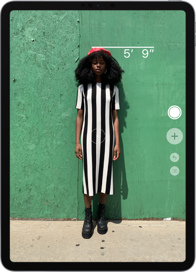 A person’s height is measured, with the height measurement showing at the top of the person’s head. The Take Picture button is active on the right edge for taking a picture of the measurement.