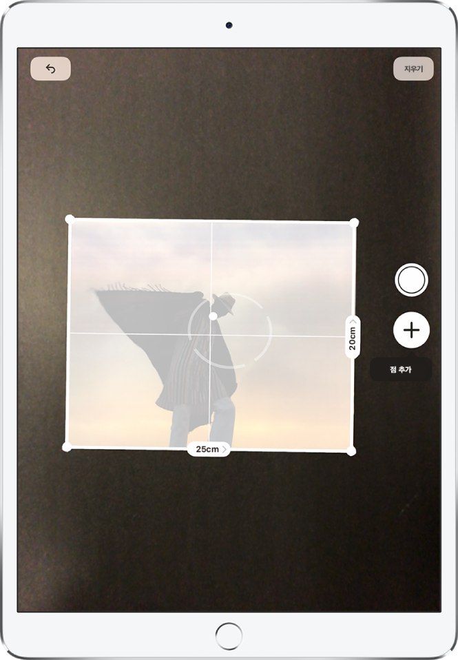 오른쪽 및 하단 가장자리를 따라 크기를 측정 중인 종이 사진. 오른쪽 가장자리 중앙 부근에 있는 사진 찍기 버튼.