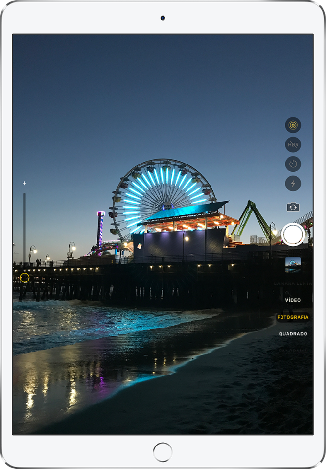 Uma imagem no ecrã Câmara, tirada do iPad Pro. O botão de obturador encontra‑se à direita, juntamente com os botões para alternar entre câmaras e para escolher um modo de fotografia.