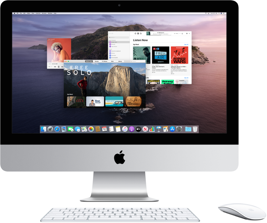 An iMac desktop showing the Music, TV, and Podcasts windows open.