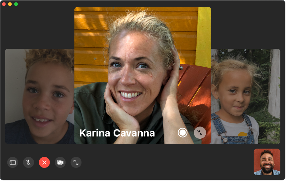 The FaceTime window showing a group call. The person who initiated the call is shown in a tile in the bottom-right corner. A large tile in the middle of the window shows a participant, along with a Live Photo button in the middle of the tile that callers can click to capture the moment.