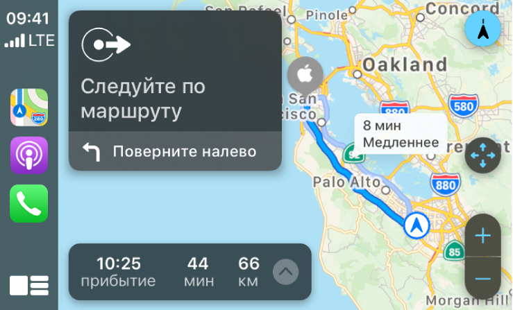 CarPlay. Слева показаны значки приложений «Карты», «Подкасты» и «Телефон», в центре — карта с автомобильным маршрутом с элементами управления масштабом, подробными инструкциями по навигации и примерным временем прибытия.