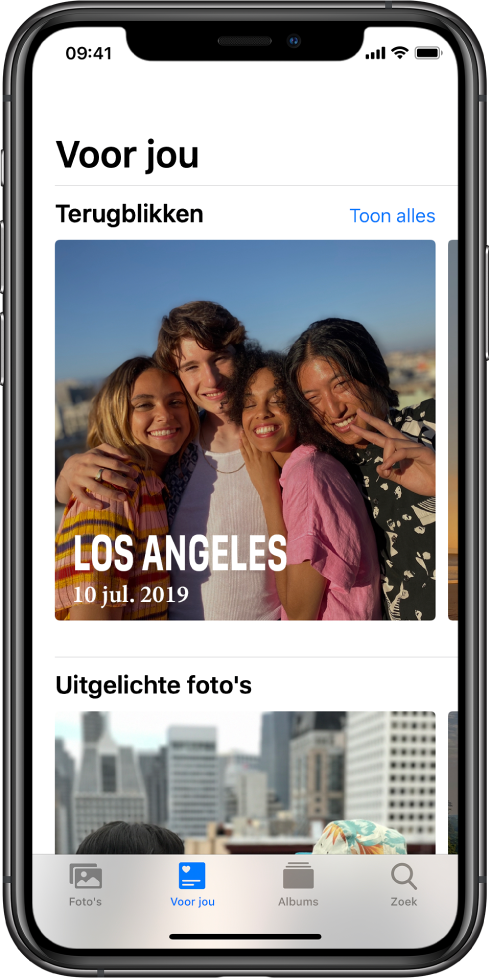 Het tabblad 'Voor jou' in de Foto's-app met het gedeelte 'Terugblikken'. De terugblik heeft een omslagfoto met de locatie en datum. Rechtsbovenin staat een knop 'Toon alles', waarmee je een overzicht van al je terugblikken weergeeft.