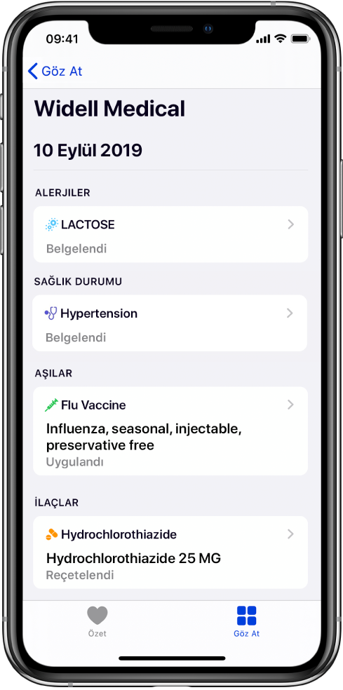 Sağlık uygulamasında ekranın üst kısmına yakın bir yerde “Widell Medical” başlığı görünür. Başlığın altında çeşitli sağlık kaydı türleri hakkında bilgiler görünür. Alerji üst kategorisi bir kayıt, Laktoz (Belgelendi) içeriyor. Sağdaki bir denetim oku kayıt için daha fazla bilginin olduğunu gösterir. Ekran Hastalıklar, Alerjiler ve İlaçlar kategorisi için ek sağlık kayıtlarını içerir.