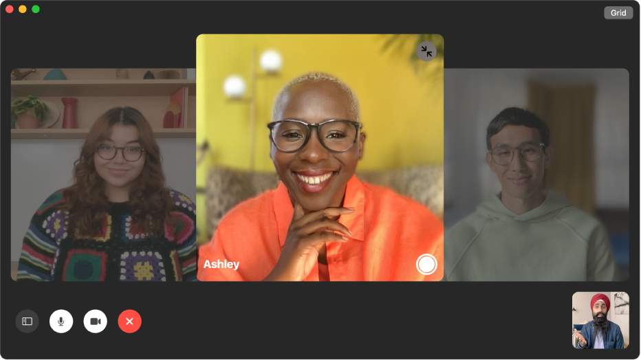 The FaceTime window showing a group call. The person who initiated the call is shown in a tile in the bottom-right corner. A large tile in the middle of the window shows a participant, along with a Live Photo button in the middle of the tile that callers can click to capture the moment.