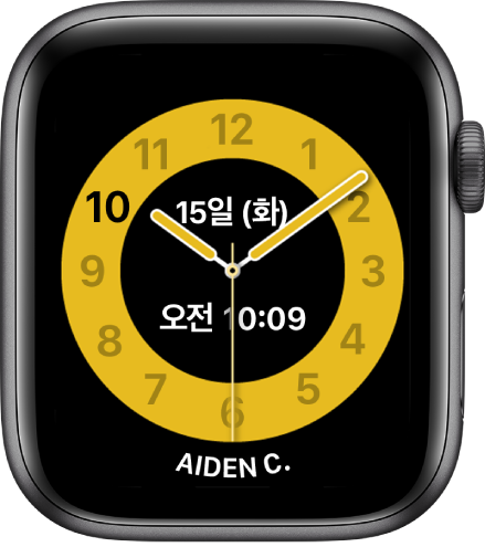 위쪽에 날짜와 그 아래 시간을 표시한 아날로그 시계를 보여주는 수업 시간 시계 페이스. 시계를 사용하는 사람의 이름이 하단에 표시됨.