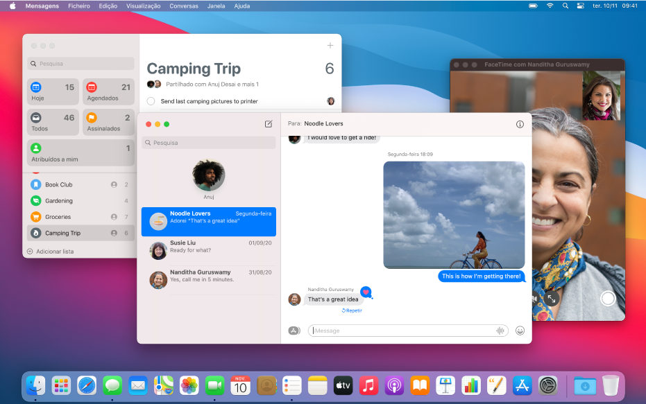 A secretária de um Mac com as aplicações Lembretes, Mensagens e FaceTime abertas. A aplicação Mensagens está em segundo plano e tem várias conversas na barra lateral e uma conversa de grupo à direita.