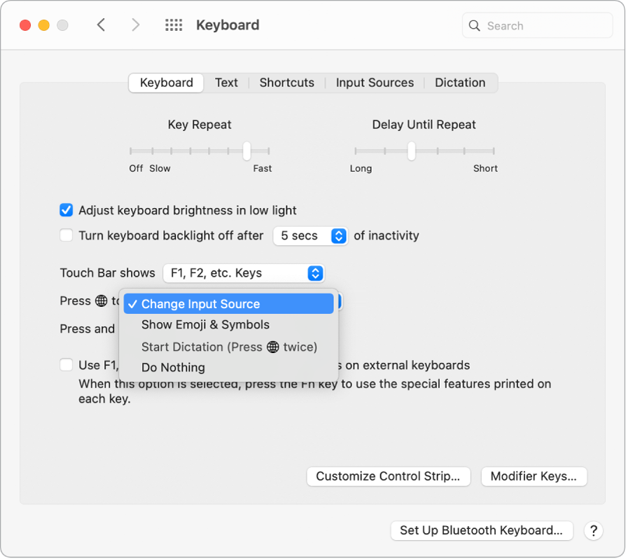 Der Bereich „Tastatur“ der Systemeinstellungen mit einem Einblendmenü, in dem Optionen für die Funktionstaste/Globustaste zu sehen sind: Eingabequelle ändern, Emoji & Symbole anzeigen, Diktat starten und keine Aktion.