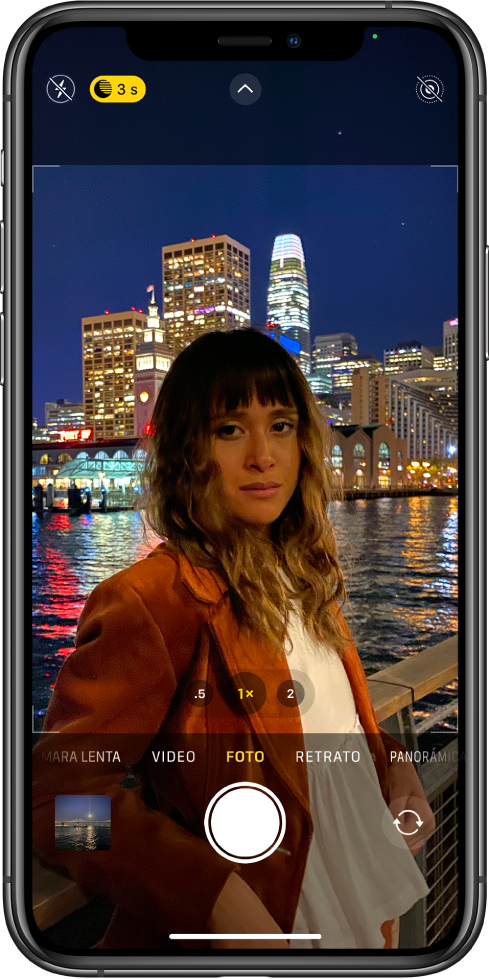 La pantalla de la app Cámara en el modo Foto. Los botones del flash y del modo Noche se muestran en la esquina superior izquierda de la pantalla. El flash está desactivado y el modo Noche está activado. El botón “Controles de cámara” está en la parte central superior, y el botón Live Photo está en la esquina superior derecha. En la parte inferior de la pantalla, de izquierda a derecha, se encuentran los botones “Visor de fotos y videos”, Tomar foto” y “Selector de cámara posterior”.