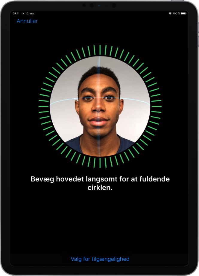 Skærmen til indstilling af genkendelse med Face ID. Der vises et ansigt omsluttet af en cirkel på skærmen. Teksten nedenunder instruerer dig i at bevæge dit hoved langsomt for at gøre cirklen færdig.