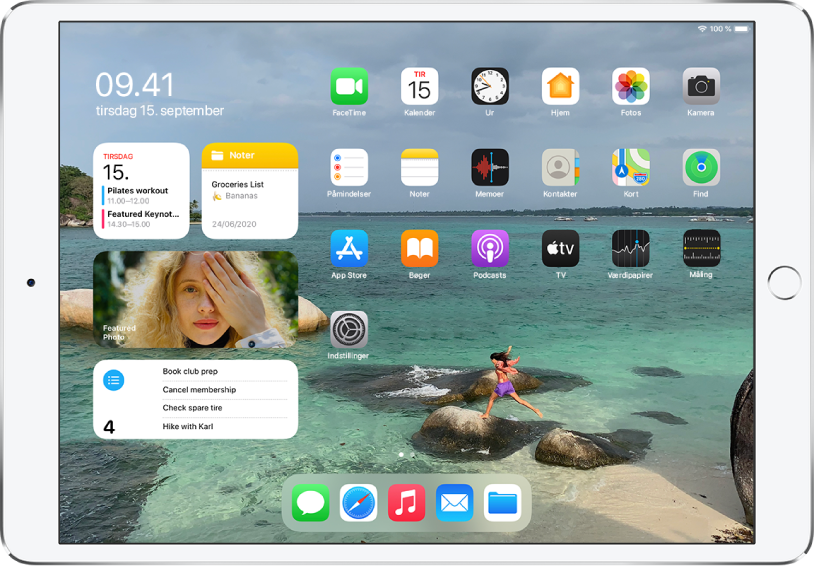 Hjemmeskærmen på iPad. I venstre side af skærmen findes Dagsoversigt med Kalender-, Noter-, Fotos- og Påmindelser-widgets. I højre side af skærmen er der apps.