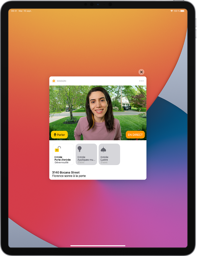 Une notification de Maison est affichée sur l’écran de l’iPad. Elle montre la photo d’une personne à la porte d’entrée avec un bouton Parler sur la gauche. Des boutons d’accessoires pour les lumières de la porte d’entrée et de l’entrée se trouvent en dessous. L’adresse du domicile et les mots « Ashley sonne à la porte » s’affichent sous les boutons d’accessoires. Le bouton Fermer s’affiche en haut à droite de la notification.