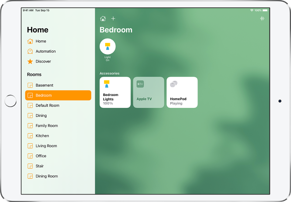 Aplikacija Home s stransko vrstico na levi. V stranski vrstici je pod Rooms izbrana soba Bedroom. Na desni strani drsne vrstice sta gumba Home in Add. Gumb Intercom je zgoraj desno. Gumb stanja za luči je blizu vrha, kar pomeni, da luč sveti. Dodatni gumbi za luči v spalnici, Apple TV in HomePod se pojavijo spodaj.