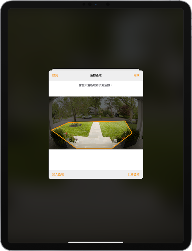 iPad 螢幕顯示門鈴攝影機所拍攝影像中的活動區域。活動區域包含門廊和走道，但不包含街道和車道。「取消」和「完成」按鈕位於影像上方。「加入區域」和「反轉區域」按鈕位於下方。