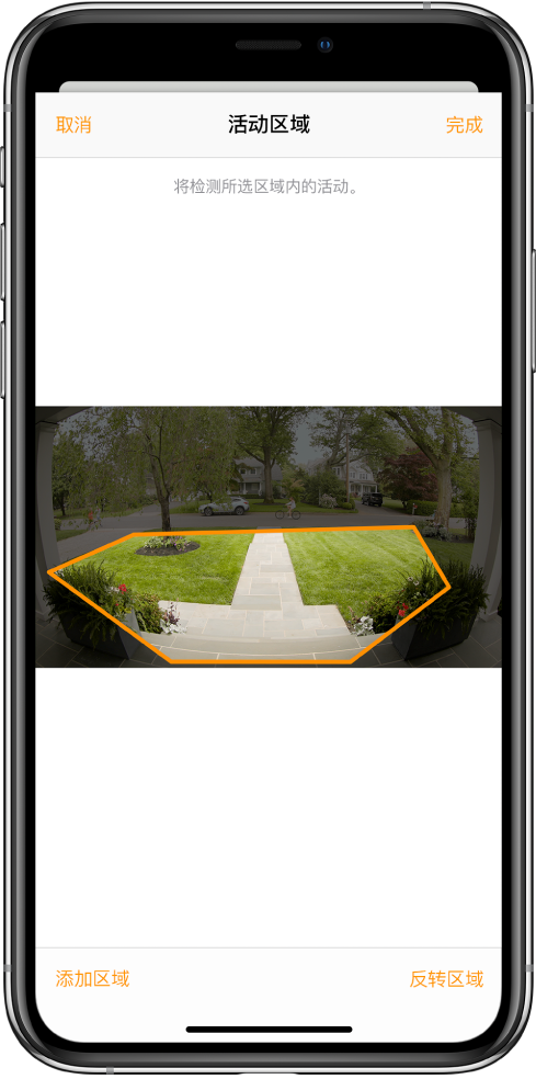 iPhone 屏幕显示活动区域，位于门铃摄像头所拍摄的图像范围内。活动区域包含前廊和走道，但不包括街道和车道。图像上方是“取消”和“完成”按钮。下方是“添加区域”和“反转区域”按钮。