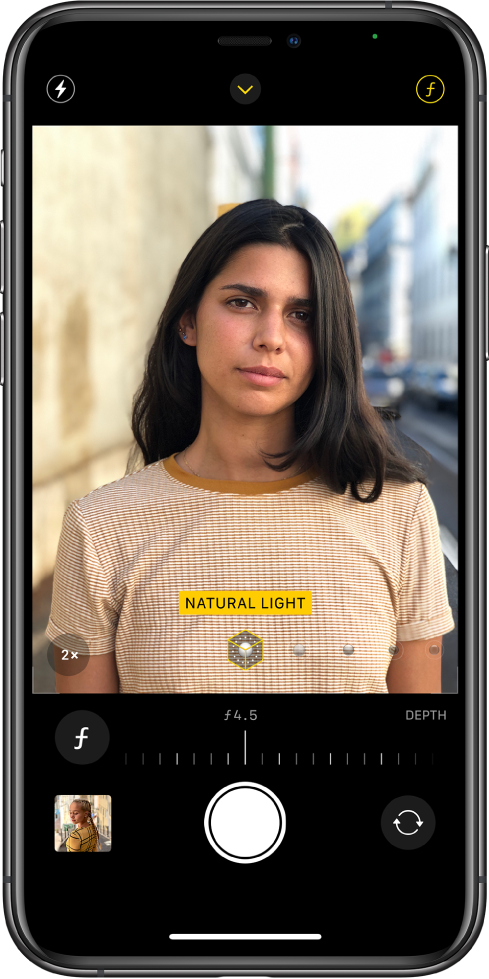 Екранът на Camera (Камера) в режим Portrait (Портрет). Избран е бутонът Depth Adjustment (Настройване на дълбочина на рязкост) в горния десен ъгъл на екрана. Във визьора на камерата полето показва, че функцията Portrait Lighting (Портретно осветление) е настроена на Natural Light (Естествено осветление), а плъзгачът може да се изтегли, за да се промени осветлението. Под визьора има плъзгач за настройване на Depth Control (Дълбочина на рязкост),