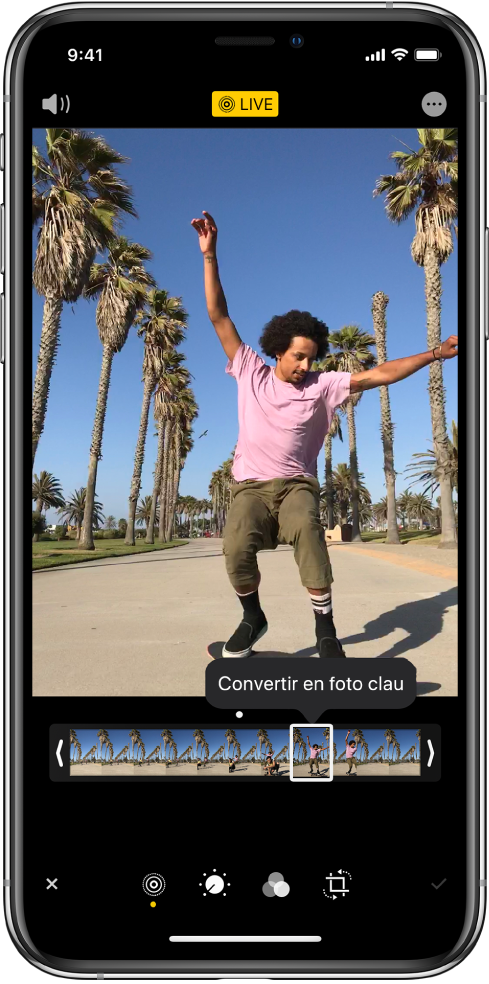 Pantalla d’una Live Photo amb la Live Photo al centre. El botó Live es troba al centre de la part superior, i el botó So a l’angle superior esquerre. A sota de la Live Photo hi ha el visor de fotogrames amb el botó “Convertir en foto clau” activat. A cada extrem del visor de fotogrames hi ha dues barres que et permeten retallar la Live Photo.