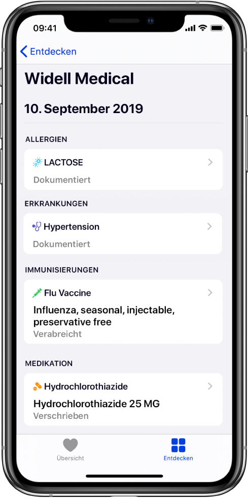 Der Titel „Widell Medical“ wird in der App „Health“ oben auf einem Bildschirm angezeigt. Unter dem Titel werden Informationen über verschiedene Typen von Gesundheitsakten angezeigt. Die obere Kategorie „Allergien“ enthält einen Eintrag „Laktose (Dokumentiert)“. Ein Pfeil auf der rechten Seite zeigt an, dass weitere Informationen für den Eintrag vorhanden sind. Der Bildschirm enthält weitere Gesundheitsakten für die Kategorien „Erkrankungen“, „Immunisierungen“ und „Medikation“.